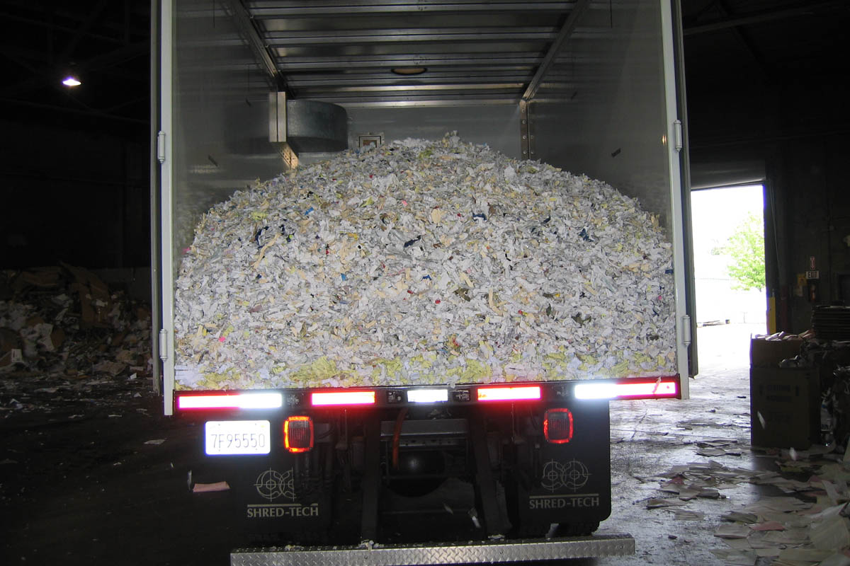 on site shredding service - mobile truck dumping shredded paper for recycling